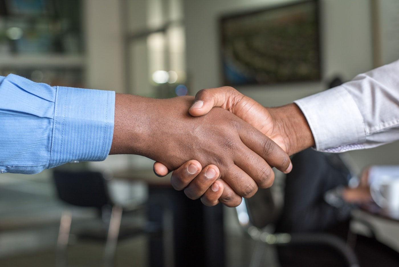 A Nexys specialist shaking hands with a client in an office
